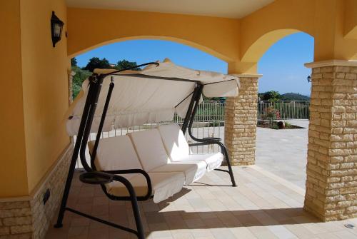 a porch with a white chair on a patio at Villa Marchesa in Castelnuovo Cilento