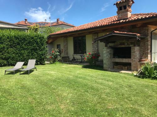 a yard with two white chairs and a fireplace at Appartamento i Tulusan a due passi dalle Langhe in Narzole