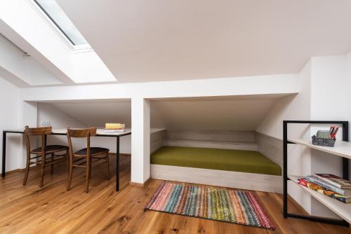 a room with a bed in a loft with a table and chairs at Fani&Rozi B&B in Maribor