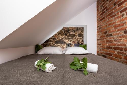 a bed with two white pillows and a brick wall at Fani&Rozi B&B in Maribor
