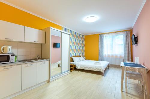 a small room with a kitchen and a bed at BonApart in Lviv