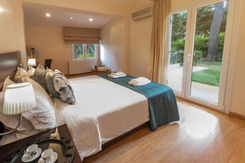 a bedroom with a large bed and a large window at Muses Villas Resort in Sani Beach