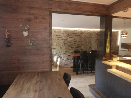 a dining room with a table and a stone wall at Gasthaus Rosenberg in Klotten