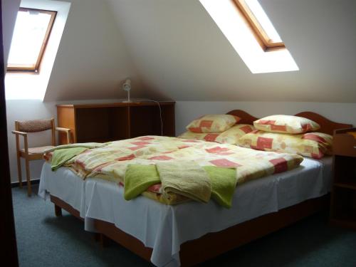 ein Schlafzimmer mit einem Bett mit einer Decke und Kissen in der Unterkunft Erika Appartementhaus in Keszthely