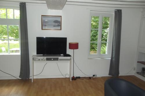 a living room with a television on a table at Le Domaine de JAUGY in Gièvres