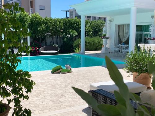 a swimming pool in a yard with a patio at White House Luxury Hospitality in Olbia