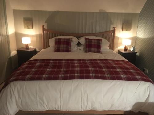 
a bed with a white comforter and pillows at Ardmore House B&B in Lochinver

