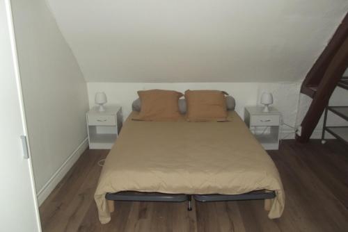 a bed in a small room with two night stands at Le Domaine de JAUGY in Gièvres