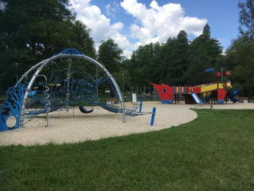 un patio de recreo en un parque con un tobogán en Apartment am Schlosspark, en Cheb