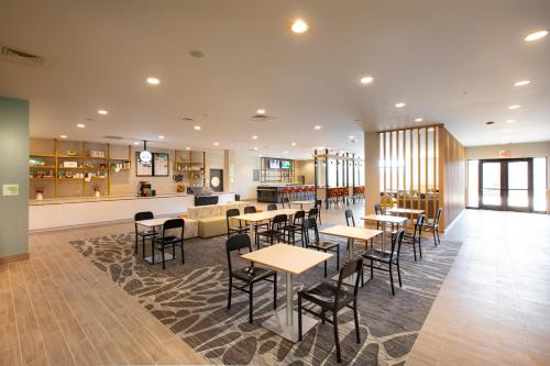 a restaurant with tables and chairs and a bar at Holiday Inn - Kansas City - Northeast by IHG in Kansas City