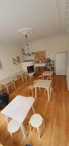 a room with tables and chairs on a wooden floor at Buch-Ein-Bett Hostel in Hamburg