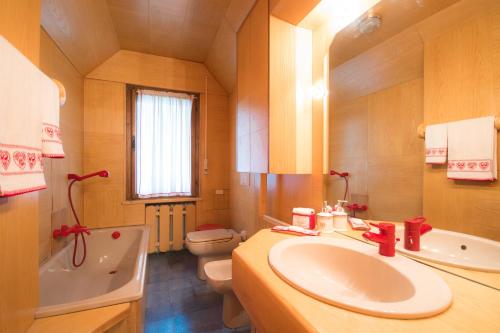 y baño con lavabo, bañera y aseo. en Casa vacanze 5 Torri, en Cortina dʼAmpezzo