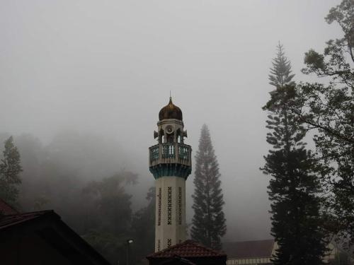 a white tower with a clock on top of it at FH Comfy Home in Bukit Fraser