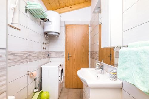 ein kleines Bad mit einem Waschbecken und einem WC in der Unterkunft Apartman Sabljak-Nerezine in Mali Lošinj