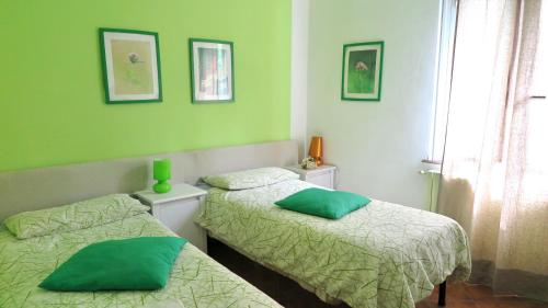 two beds in a room with green walls at Cà di felice-locanda dei cacciatori in Campomorone