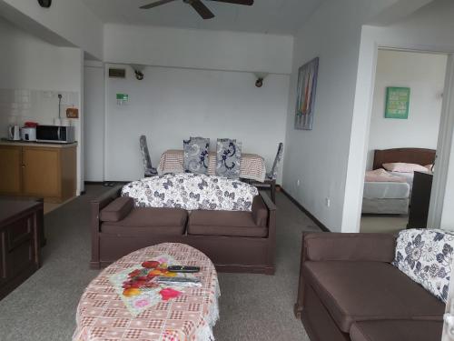 uma sala de estar com um sofá, um sofá e uma mesa em FH Comfy Home em Bukit Fraser