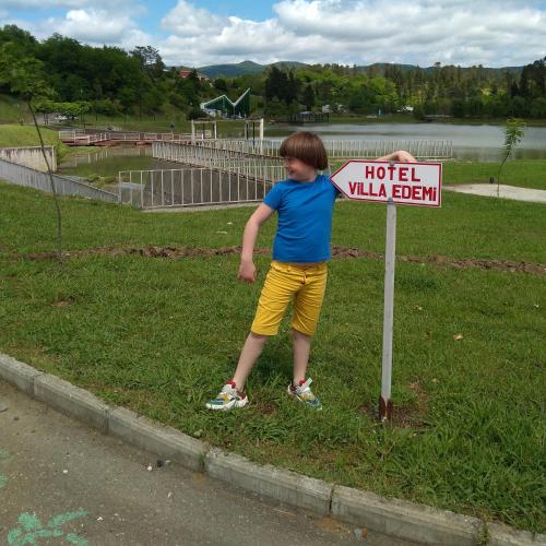 a young boy standing next to a hotel sign at Villa Edemi in Tskaltubo