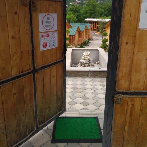 an entrance to a building with a green door and a fountain at Villa Edemi in Tskaltubo