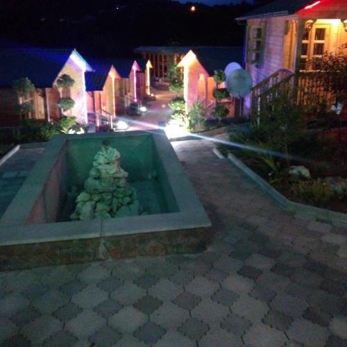 a fountain in the middle of a yard at night at Villa Edemi in Tskaltubo