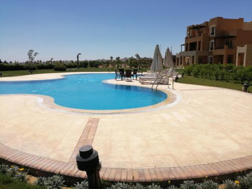 a swimming pool in a yard with a patio at Studio in Byoum by Qaroun lake in Fayoum in Qaryat at Ta‘mīr as Siyāḩīyah