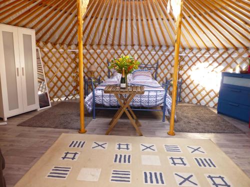 a room with a bed and a table in a yurt at Les Yourtes d'Agnac in Agnac