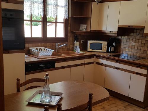 La cuisine est équipée d'une table, d'un évier et d'un four micro-ondes. dans l'établissement La Quietude, à Amboise