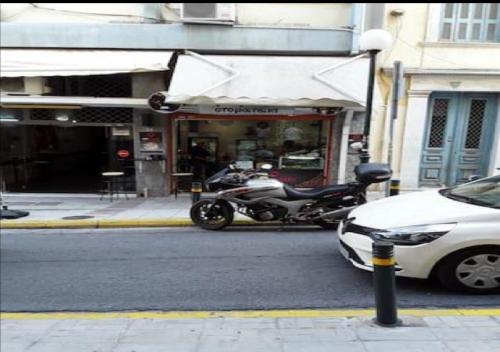 a motorcycle parked in front of a store on a street at House in the center of Piraeus next to the port and the metro!! in Piraeus