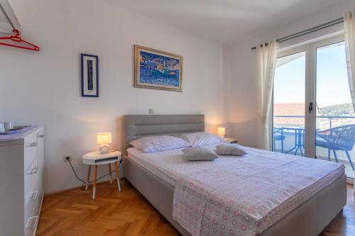 Habitación blanca con cama y balcón. en Apartments Jakic 1 en Hvar