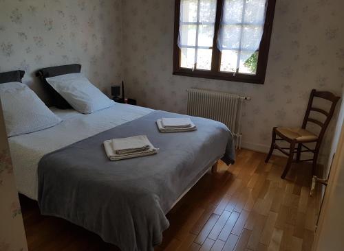 a bedroom with a bed with two towels on it at La Quietude in Amboise