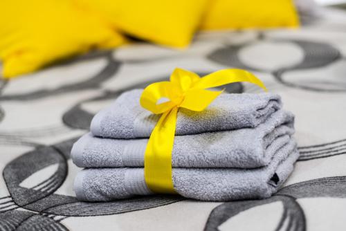 a pile of towels with a yellow bow on top at BLACK & YELLOW Centrally located studio in Novi Sad