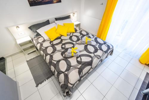 - une chambre avec un lit et des oreillers jaunes dans l'établissement BLACK & YELLOW Centrally located studio, à Novi Sad