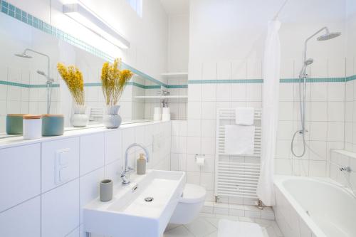 a white bathroom with a sink and a toilet at Family-friendly Waterfront Loft, 3 Bedrooms, 130 m2 in Berlin