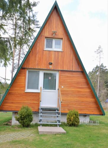 a house with a gambrel roof with a white door at Chatky Sázava in Sázava