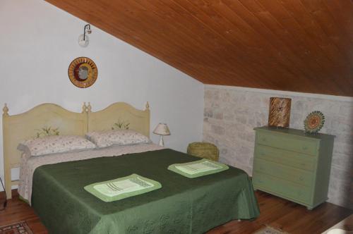 um quarto com uma cama verde e uma cómoda em B&B Al cortiletto Modica centro em Modica