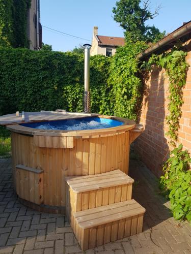 una bañera de hidromasaje de madera en un patio con en Wooden House near City center, en Riga