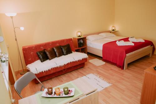 a hotel room with two beds and a couch at Apartman Buba in Palić