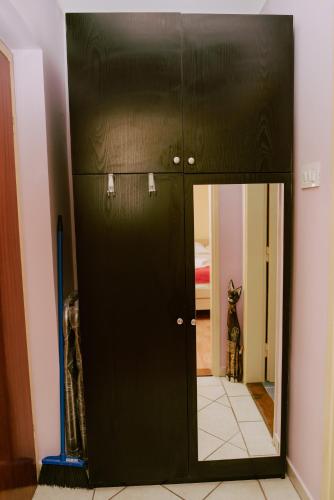 a black door with a mirror in a room at Apartman Buba in Palić