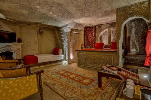 a room with a bed and a couch and a table at Hidden Cave Hotel in Göreme