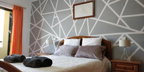 una camera da letto con un letto con una parete con accento geometrico di Holiday House ad Albufeira
