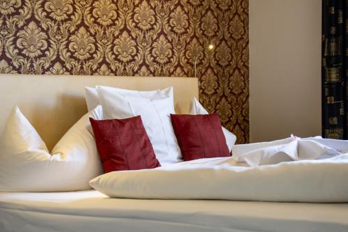 A bed or beds in a room at Hotel De Lange Man Monschau Eifel