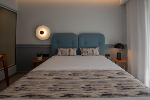 a bedroom with a large bed with a blue headboard at Charisma Boutique Hotel in Parga
