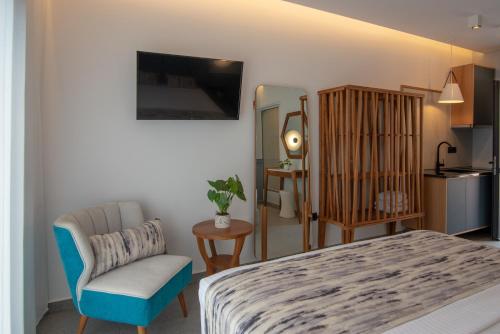 a bedroom with a bed and a chair and a kitchen at Charisma Boutique Hotel in Parga