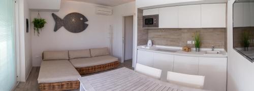 uma sala de estar com um sofá e um lavatório em MARINA PONENTE em Lido di Jesolo
