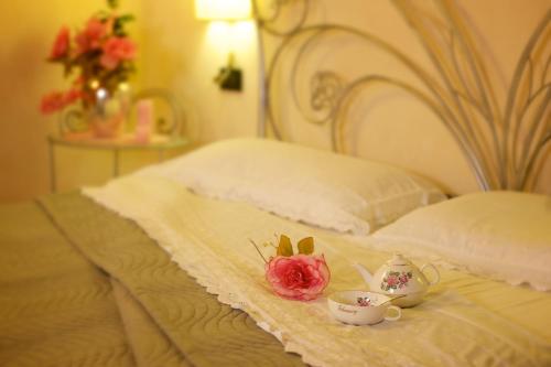 a bed with two tea cups and roses on it at Agriturismo Il Felciaione in Massa Marittima