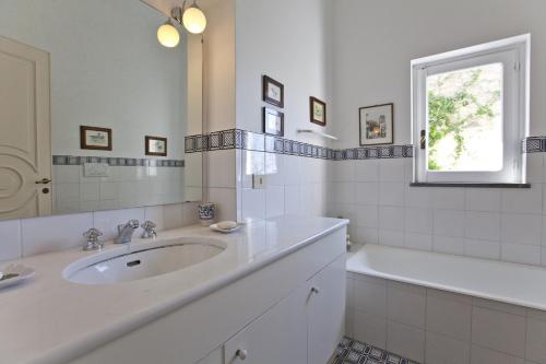 a bathroom with a sink and a tub and a window at Villa Stella in Massa Lubrense