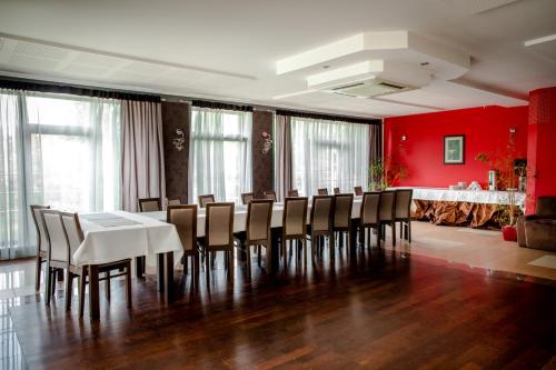 a dining room with red walls and a table and chairs at Restauracja Sonata in Zwierzyniec