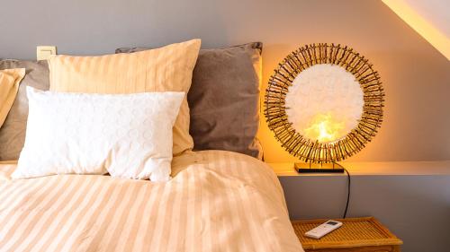 a bed with a white pillow and a mirror at Le Jardin Des Secrets "Gites et chambres à louer" in Namur