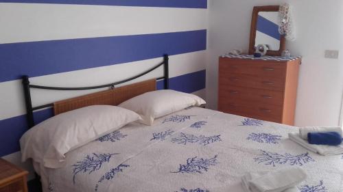 マルサラにあるCasa Vacanze Escondidoのベッドルーム1室(青と白のベッド1台、枕2つ付)