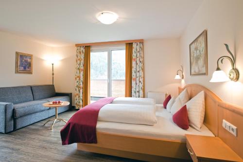 a hotel room with a bed and a couch at Hotel Truyenhof in Ried im Oberinntal