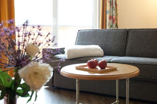 a living room with a couch and a table with apples on it at Hotel Truyenhof in Ried im Oberinntal